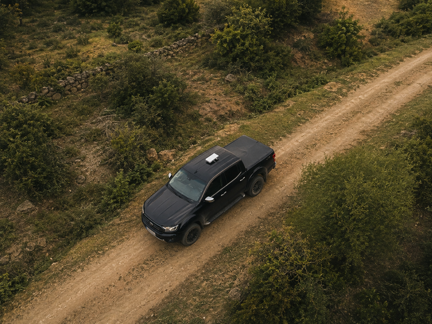 Pick-up negra en trocha con Starlink Mini en el techo